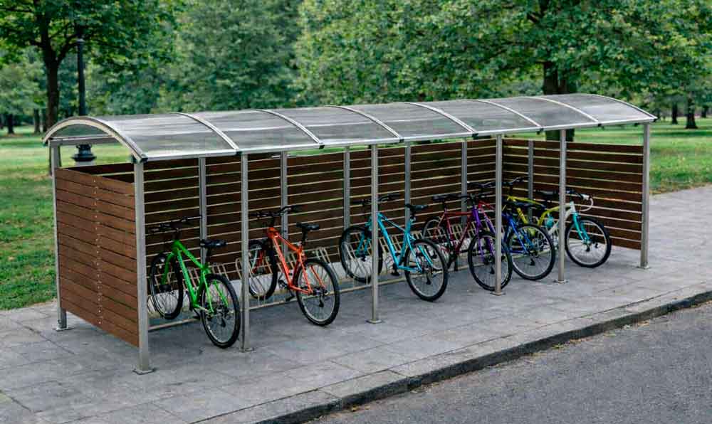 Marquesina aparcabicicletas cubierta de madera y acero con varias bicicletas en exterior